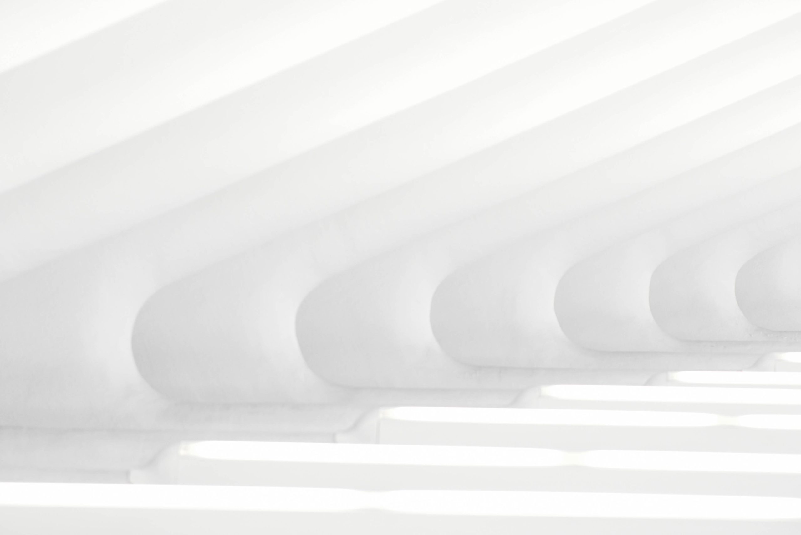 abstract white background waving lines starting in the right hand corner and bending in a 90 degrees round shape to the left corner 